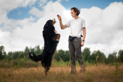 Full length of man with dog standing on field