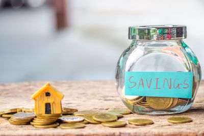 Close-up of coins in jar on wooden table