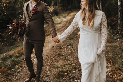 Midsection of couple standing by plants