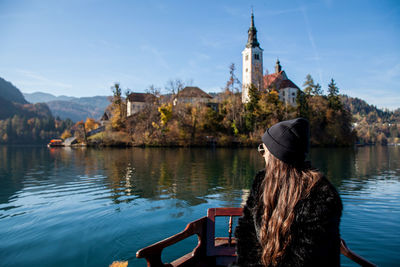 Woman sitting on boat in lake against sky