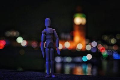 Miniature on retaining wall against illuminated big ben at night