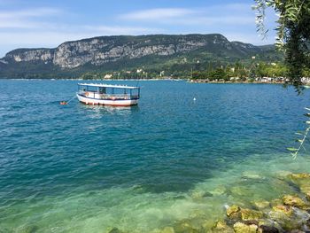 Boats in sea with mountains in background