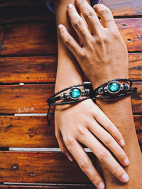 Cropped hands of couple wearing bracelets at table