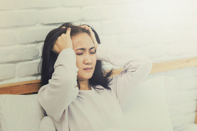 Young woman lying on wall at home