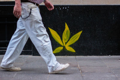 Low section of man standing on footpath