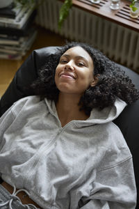 Portrait of smiling young woman lying on bean bag