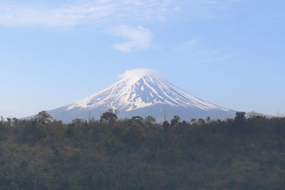 Mount fuji and the mountain range covered by trees on a clear day,traveling in japan.