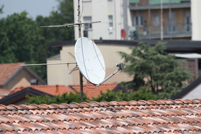 Satellite dish on roof against buildings