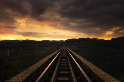 Railroad tracks against sky during sunset