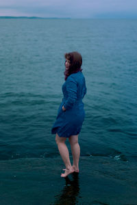 Side view of woman standing in sea