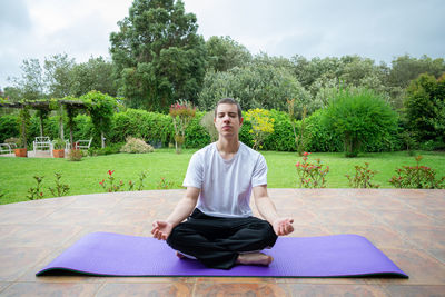 Portrait of man sitting on table against trees