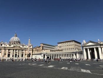 Group of people in front of building against blue sky