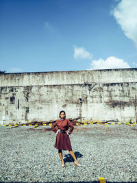 Full length portrait of woman against sky