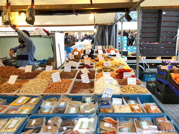 Vendor standing by food on display at market stall