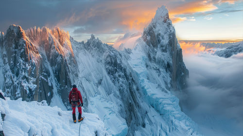 Rear view of snow covered mountain against sky during sunset