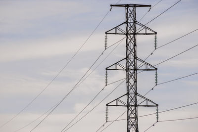 Low angle view of electricity pylon against sky