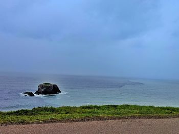 Scenic view from country road cliff of ocean against sky