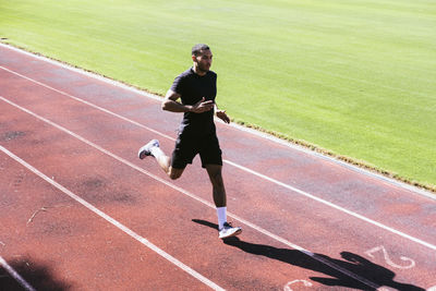 Pulled back view of african american athlete running on track