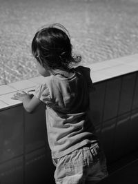 Rear view of woman standing in swimming pool