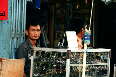 Portrait of man selling sunglasses in market