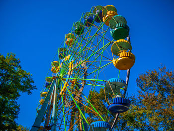 Low angle view of ferris wheel against blue sky