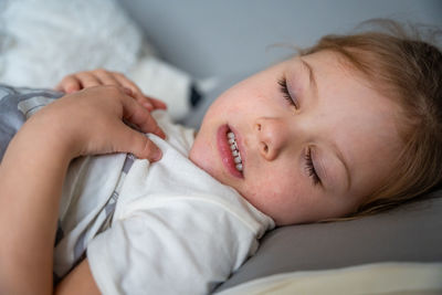 Close-up of baby sleeping on bed at home