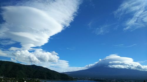 Scenic view of sea and mountains against blue sky