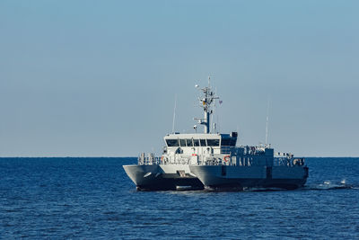 Ship sailing on sea against clear sky