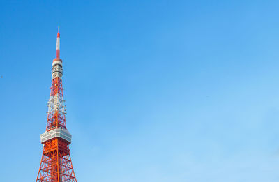 Low angle view of communications tower against blue sky