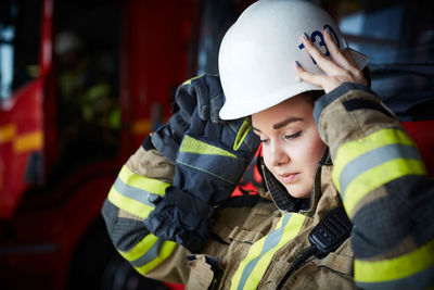 Female firefighter wearing helmet while looking down at fire station