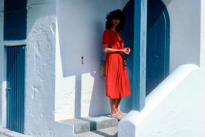 Woman standing against house