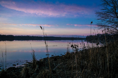 Scenic view of lake against sky at sunset