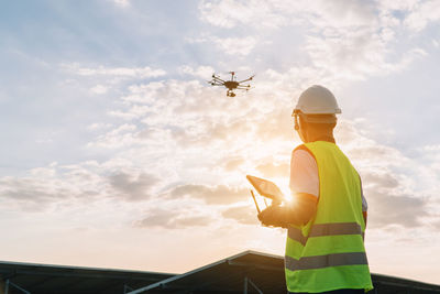 Low angle view of man standing by airplane against sky