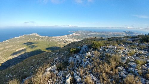 Scenic view of sea and mountains against blue sky