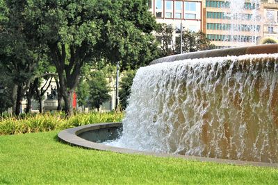 View of fountain in park against buildings