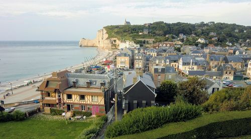 High angle view of townscape by sea against sky