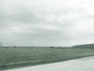 Scenic view of field against storm clouds