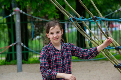 Close up happy little child girl play and sitting on the swing in the nature park.