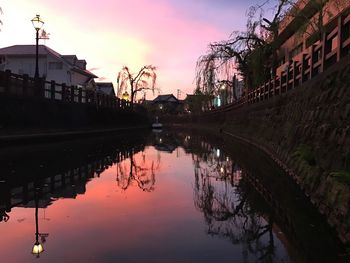 Reflection of buildings in lake during sunset