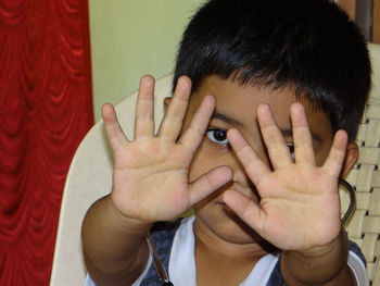 Portrait of a boy covering face