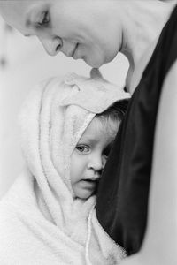 Close-up portrait of cute baby girl with mother at home