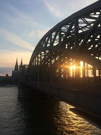 Bridge over river in city against sky