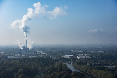 High angle view of smoke emitting from factory against sky