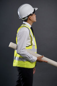 Man wearing hat while standing against gray background