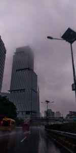 City street by buildings against sky at dusk