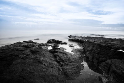 Rock formations by sea against sky