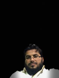 Portrait of young man against black background