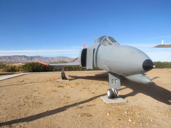 Coin-operated binoculars on airport runway against clear blue sky