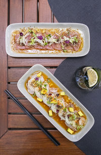 Two plates with tuna and red snapper carpaccio, candid light, top view , vertical composition