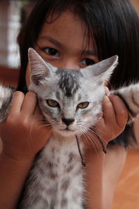 Close-up portrait of girl holding kitten